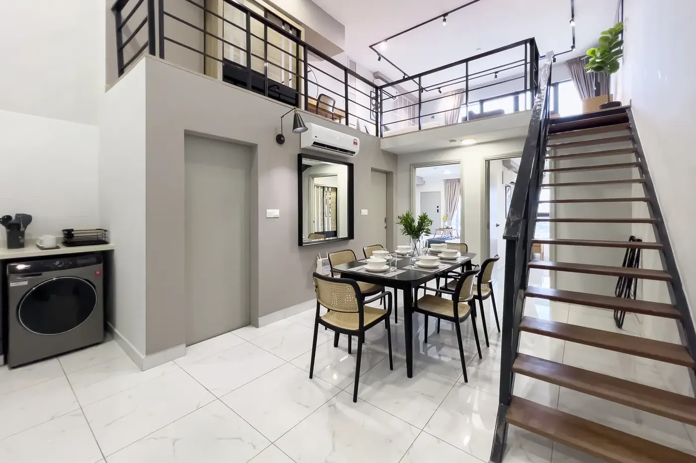 Double-height dining area and open staircase to the loft in an Arte Cheras unit managed by WefieHome