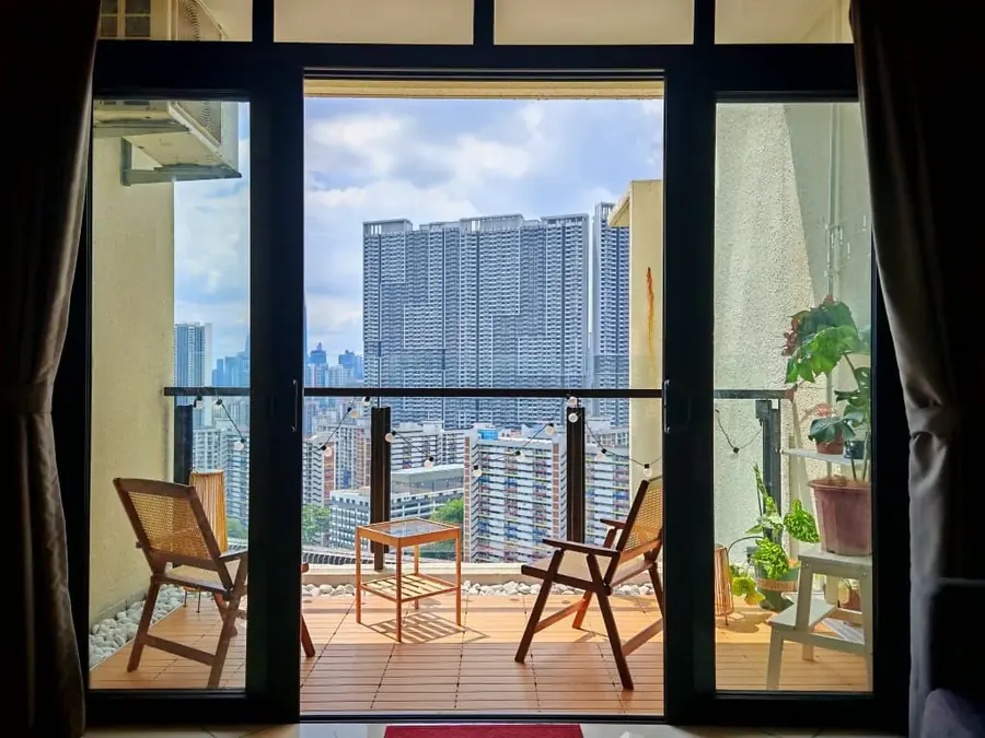Balcony with timber decking, rattan chairs and plants in a condo managed by WefieHome